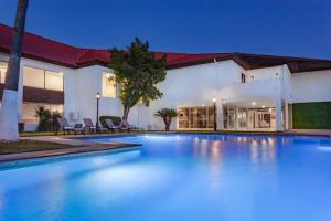 - une piscine en face d'une maison dans l'établissement Days Inn by Wyndham Piedras Negras, à Piedras Negras
