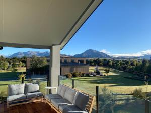 a patio with couches and a view of the mountains at ValleyView Wanaka in Wanaka