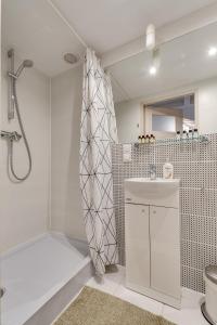 a white bathroom with a shower and a sink at Apartament Szczęśliwa Trzynastka in Gliwice