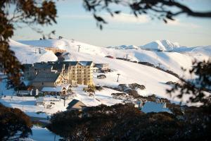 un resort en la nieve con montañas en el fondo en Absollut, en Monte Hotham