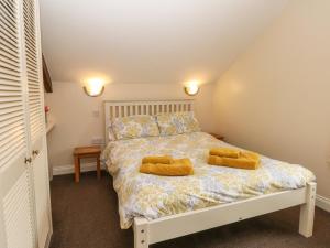 a bedroom with a bed with two yellow pillows on it at The Loft in Buxton