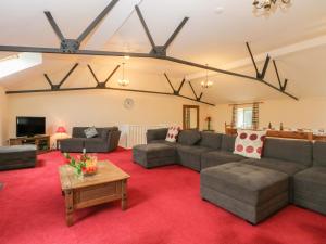 a living room with couches and a red carpet at Woodlands in Buxton