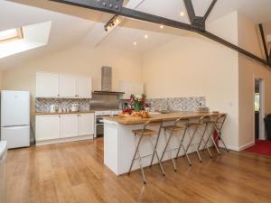 a kitchen with white cabinets and a wooden floor at Woodlands in Buxton