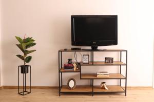 uma televisão num suporte de televisão numa sala de estar em Apartman Hana em Lički Osik
