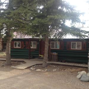 een groene hut met bomen ervoor bij Riverbend Resort in South Fork