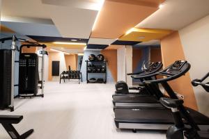 a gym with treadmills and ellipticals in a room at Hyatt Regency Malta in St. Julianʼs