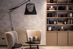 a room with a chair and a lamp and a book shelf at Hyatt Regency Malta in St. Julianʼs