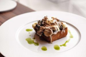a piece of cake on a white plate with syrup at Hyatt Regency Malta in St. Julianʼs