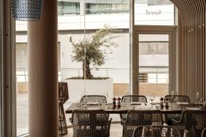 a table and chairs in a room with a large window at Hyatt Regency Malta in St. Julianʼs