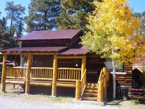 uma cabana de madeira com um alpendre e um deque em Riverbend Resort em South Fork