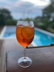 a drink in a glass on a table next to a pool at Reduto do Alto in Búzios