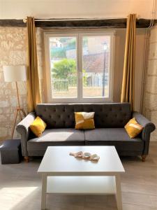 a living room with a couch and a table at Gîte de l'Horizon, 5mn du Zoo de Beauval in Seigy