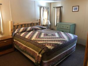 a bedroom with a bed and a blue dresser and a bed sidx sidx sidx at Riverbend Resort in South Fork