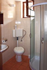 a bathroom with a toilet and a sink and a shower at Apartments Marija - 30m from the beach in Murter