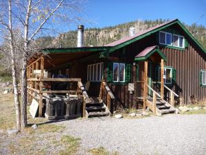 a log cabin with stairs leading up to it at Riverbend Resort in South Fork