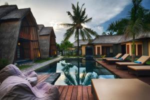 a resort with a swimming pool and a villa at Kies Villas Lombok in Kuta Lombok