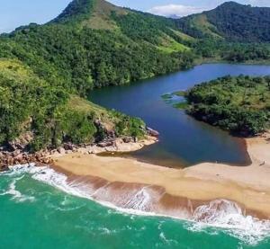 an aerial view of a body of water with a beach at Honey Moon - Vista do mar na cama. in Caraguatatuba