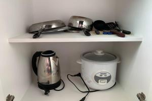 a shelf with a toaster and a tea pot on it at Anuva Condominium with Netflix in Manila