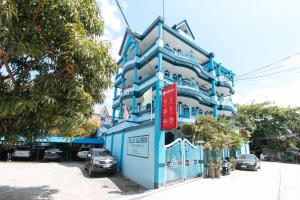 マニラにあるRedDoorz Plus Villa Gloria Taguigの通路脇の青白の建物