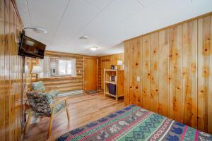 Un dormitorio con paredes de madera y una cama y una silla. en Sportsman's Lodge, en Ennis