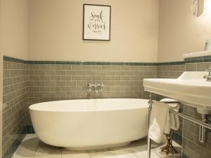 a bathroom with a white tub and a sink at The Wilder in Dublin
