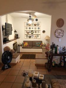 a living room with a bench and plates on the wall at Casa De Campo Boituva in Boituva