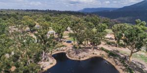 eine Luftaufnahme eines Sees mit einer Brücke in der Unterkunft Banksia Park Cottages in Kangaroo Valley