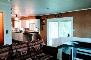 a living room with a couch and a table and a kitchen at Wisconsin Dells Cabin in the Woods - VLD0423 in Wisconsin Dells