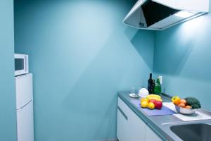東京的住宿－PLAYSIS Asakusa，蓝色的厨房,在柜台上摆放水果和蔬菜