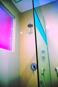 a bathroom with a shower with a sign on the wall at favehotel Gatot Subroto Jakarta in Jakarta
