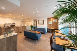 a waiting room with blue chairs and tables at Port House Hatsudai in Tokyo