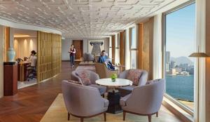 - un hall d'accueil avec des chaises, une table et une fenêtre dans l'établissement Mandarin Oriental, Hong Kong, à Hong Kong