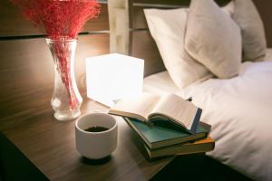 einen Tisch mit einem Buch und einer Tasse Kaffee und einer Lampe in der Unterkunft PLAYSIS Asakusa in Tokio