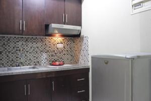 una cucina con lavello e frigorifero di Strategic & Cozy 2BR at Majesty Apartment near Maranatha Christian University By Travelio a Bandung