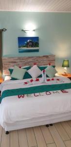 a bedroom with a large white bed with flowers on it at La Digue Self-Catering Apartments in La Digue