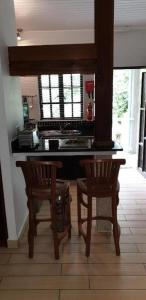 a kitchen with two chairs and a table and a counter at La Digue Self-Catering Apartments in La Digue