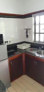 a small kitchen with a sink and a refrigerator at La Digue Self-Catering Apartments in La Digue