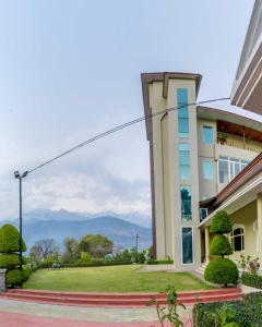 - un bâtiment avec vue sur les montagnes dans l'établissement juSTa Palampur Resort & Convention Centre, à Palampur