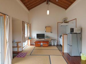 a kitchen with a refrigerator and a table at Kaeruya in Nakijin