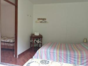 a bedroom with a bed and a table with a phone at Illariy Tampu Ecoalbergue Oxapampa in Oxapampa