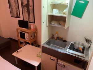a small kitchen with a sink and a microwave at Exsaison Shirokita 603 in Osaka
