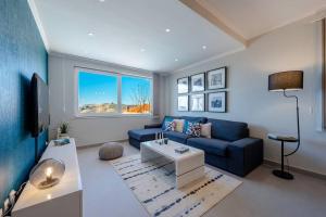 ein Wohnzimmer mit einem blauen Sofa und einem Tisch in der Unterkunft Lovely Lucia's house in Dubrovnik