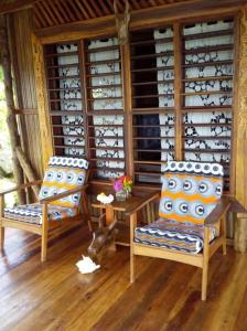 two chairs and a table in a room with wine glasses at Remo e Berenice in Nosy Komba