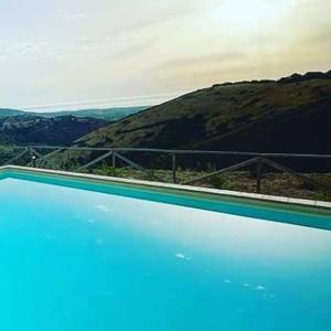 une grande piscine avec vue sur la montagne dans l'établissement Azienda Agrituristica La Janna di la Faj, à Budoni