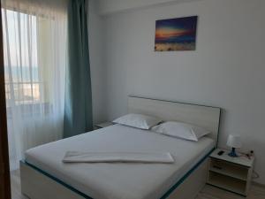 
Un pat sau paturi într-o cameră la Mamaia Dorin Apartment
