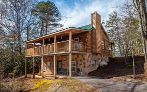 een blokhut in het bos met een balkon bij Sleepin' Inn Holiday home in Sevierville