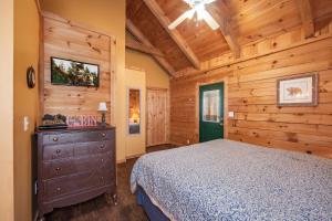 een slaapkamer met een bed en een houten muur bij Sleepin' Inn Holiday home in Sevierville