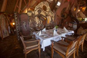 a dining room with a table and chairs and a mural at Chui Lodge in Naivasha