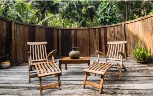 two chairs and a table and a vase on a patio at The Barefoot At Havelock in Havelock Island