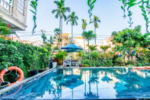 uma piscina num resort com palmeiras em Relax Garden Boutique Villa Hoi An em Hoi An